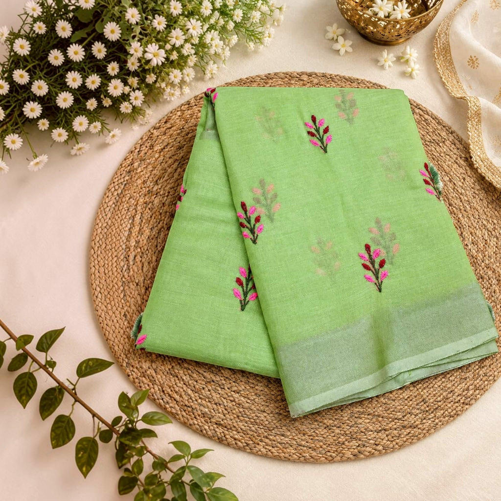 City Center light green linen cotton saree with delicate pink and green floral butti embroidery on a woven mat