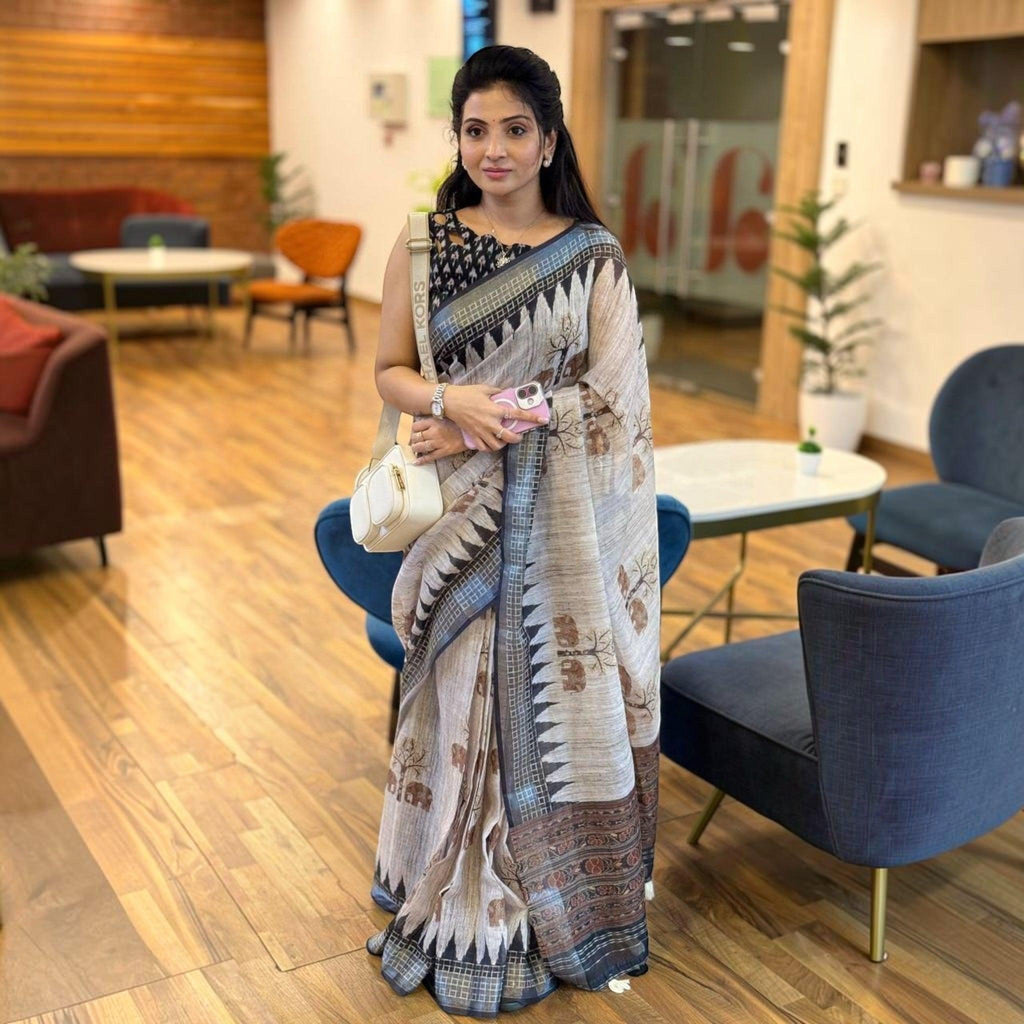 City Center premium cotton saree in beige with black geometric borders and tree motifs worn by a woman indoors