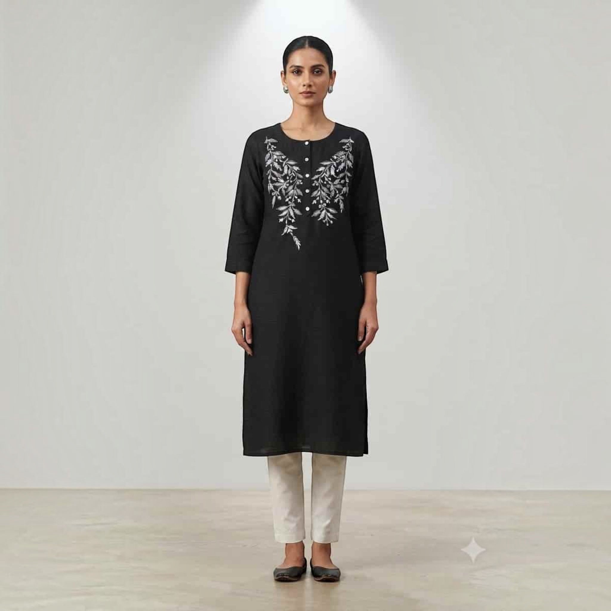 City Center black knee-length Lodgy kurti with white floral embroidery, worn by a model with beige trousers.