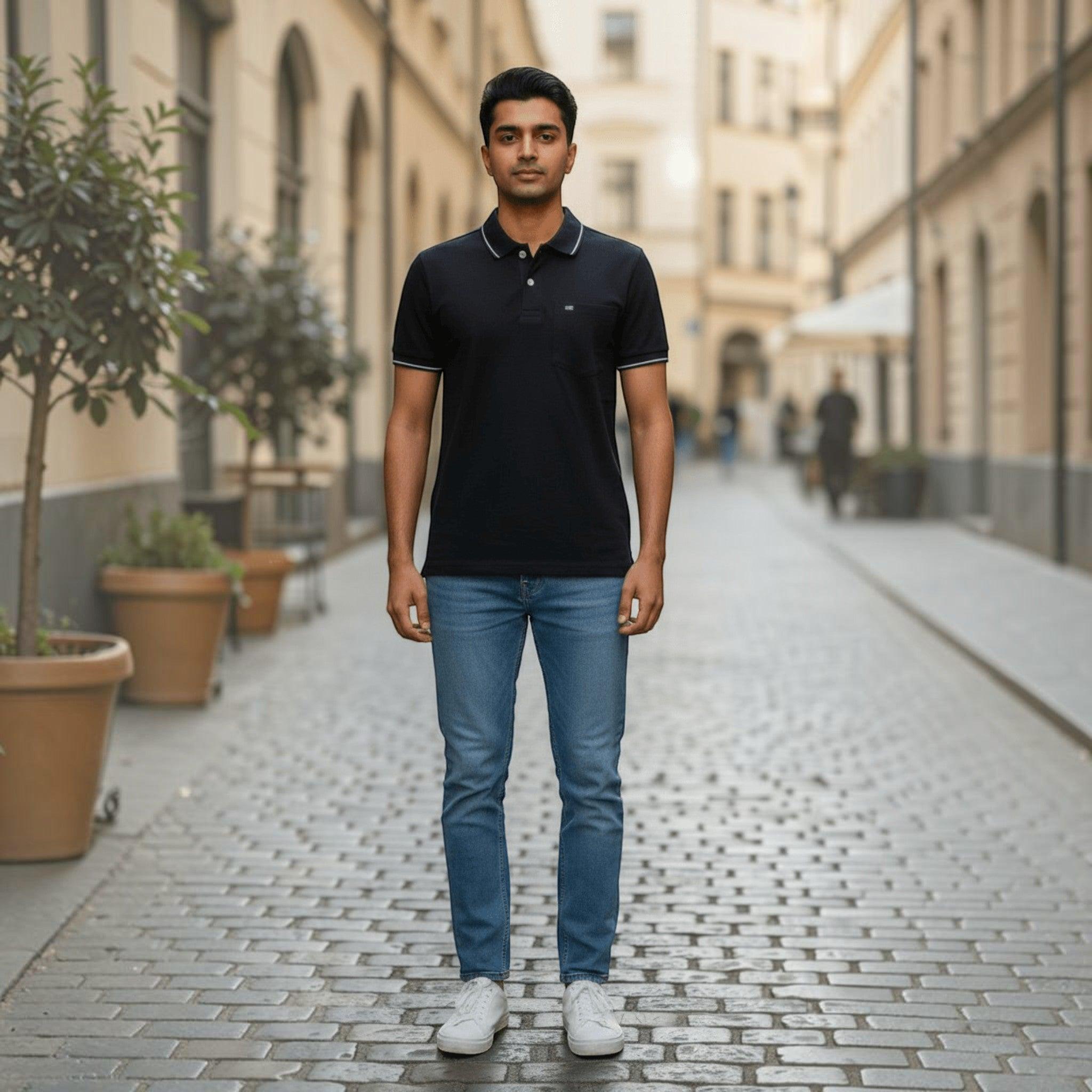 City Center men's black polo shirt with white collar trim, paired with blue jeans and white sneakers on a city street.