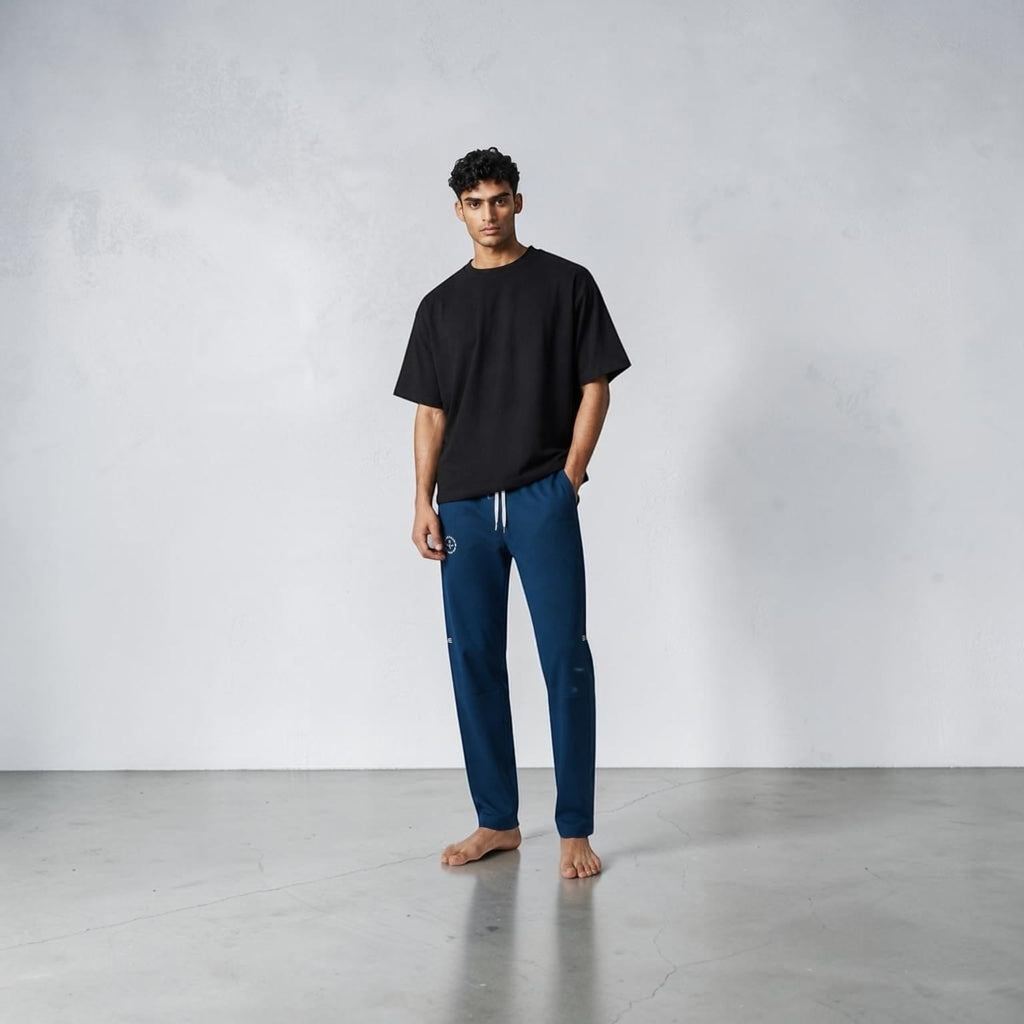 City Center blue casual track pants with an elastic waistband and deep pockets worn by a man in a black t-shirt