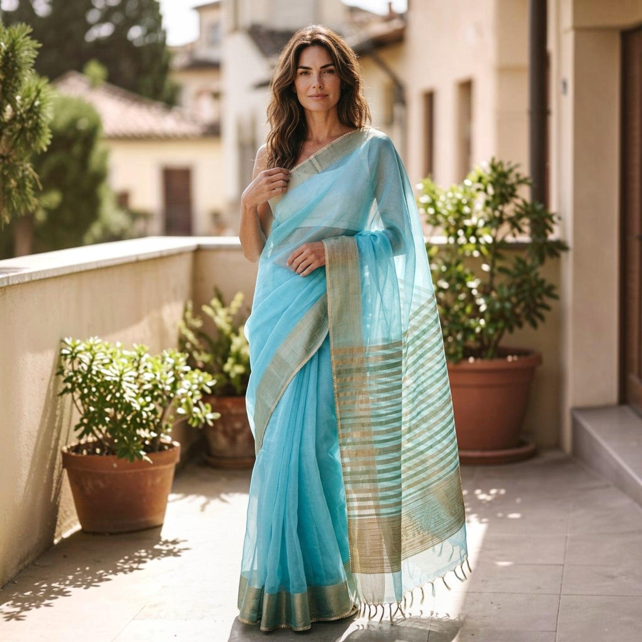 City Center light blue organza saree with gold zari border worn by a woman on a sunny terrace