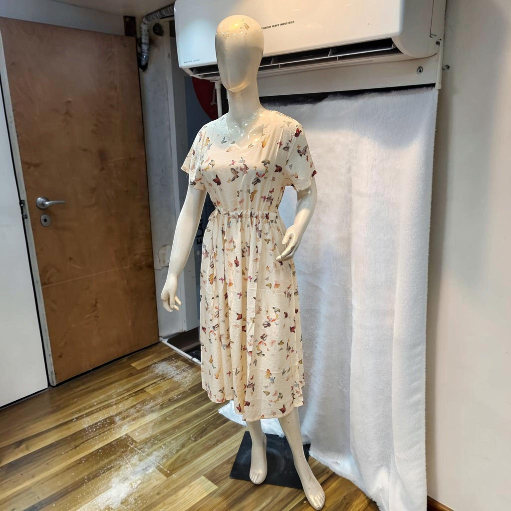 City Center cream midi dress with butterfly print, short sleeves, and a cinched waist on a mannequin