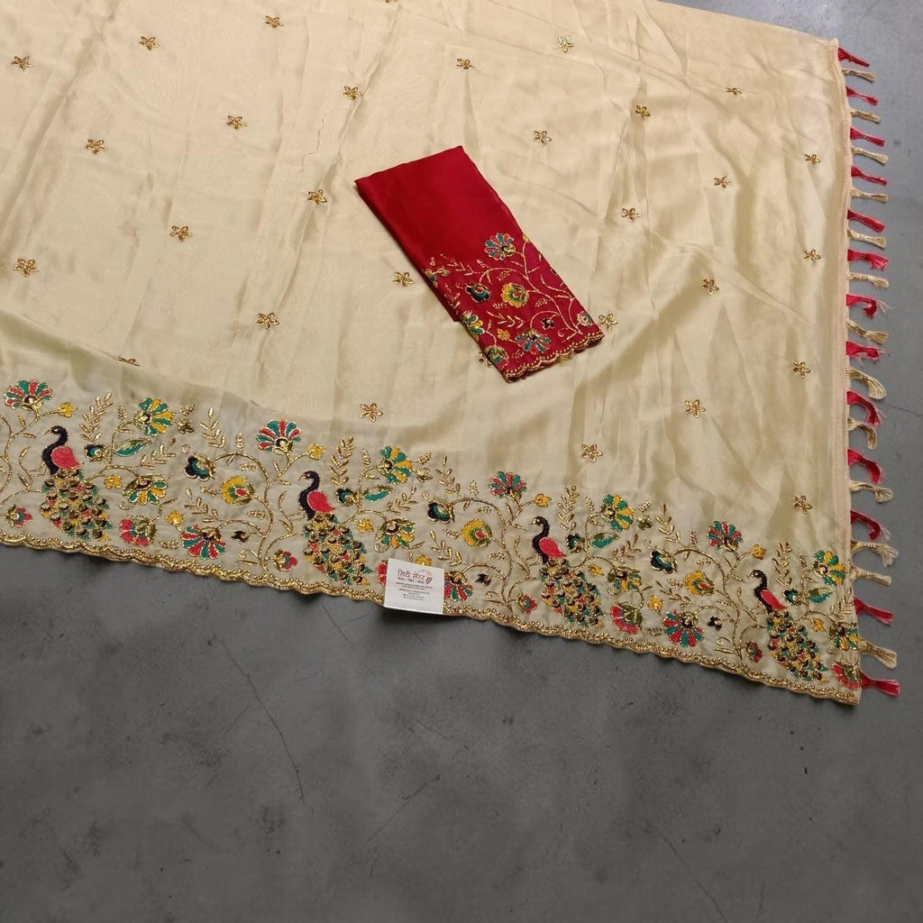 City Center traditional cream saree with vibrant peacock embroidery, floral motifs, and a matching red blouse piece.