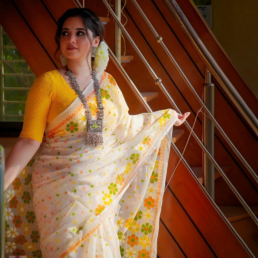 City Center premium cotton saree in white with orange and green floral motifs, paired with a vibrant yellow blouse.