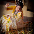 City Center premium cotton saree in white with yellow and orange floral motifs, worn with a mustard yellow blouse.