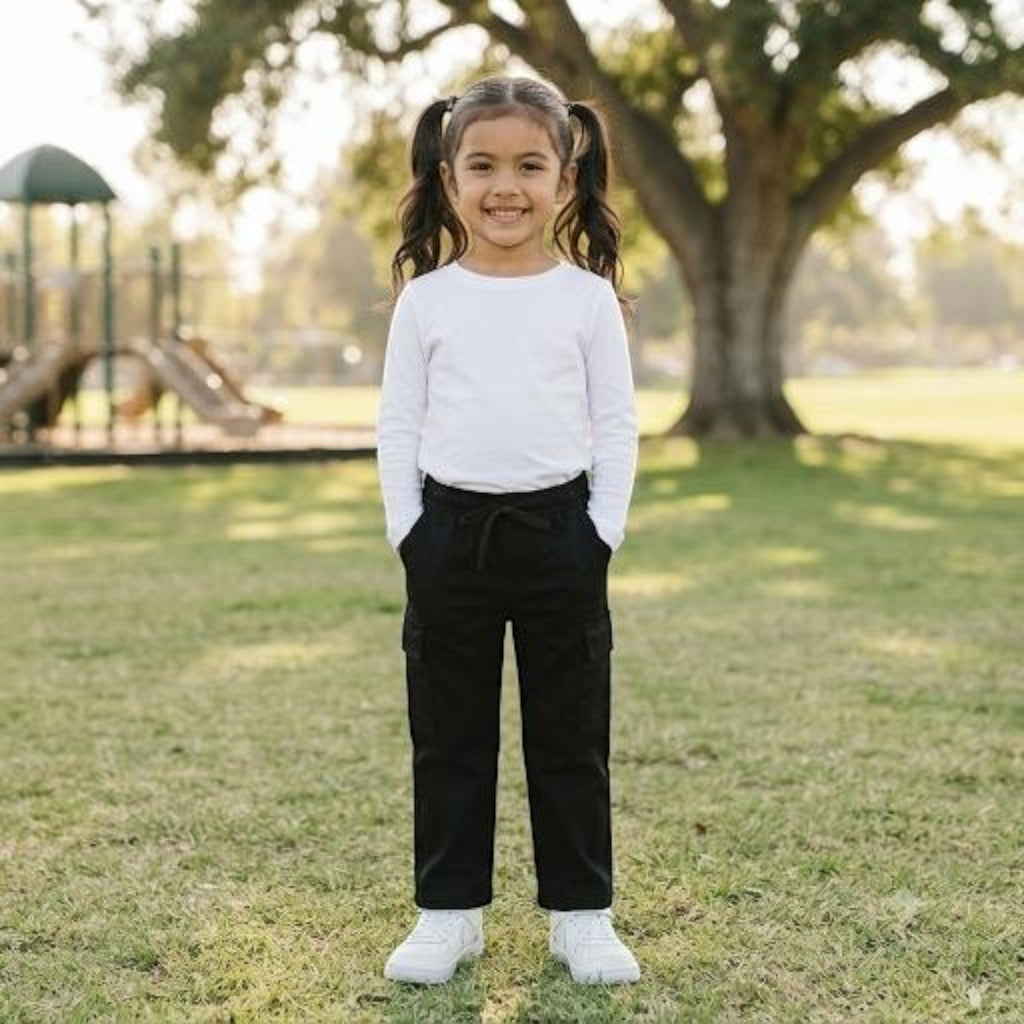 City Center girls black ethnic cargo pants with elasticated waist worn with a white long sleeve top in a park