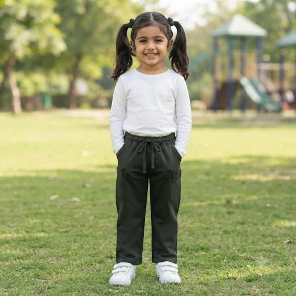 City Center girls ethnic pant in dark green with an elasticated drawstring waist, worn by a smiling girl in a park.