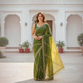 City Center green organza saree with intricate beadwork and a contrasting yellow pallu worn by a woman outdoors.