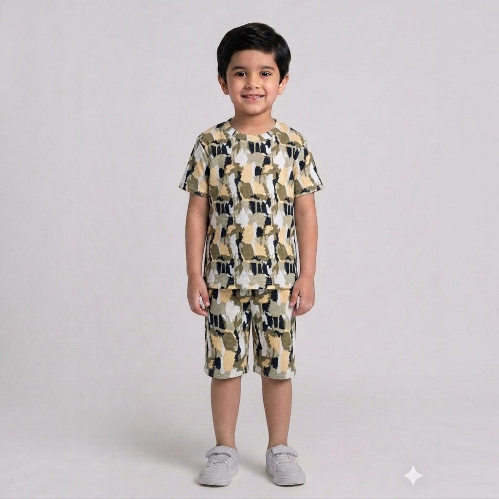 City Center kids cotton co-ord set with a playful abstract camo print in olive, black, and cream on a young boy.