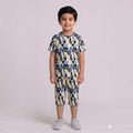 City Center kids cotton co-ord set with a blue, yellow, and grey abstract print worn by a smiling young boy.