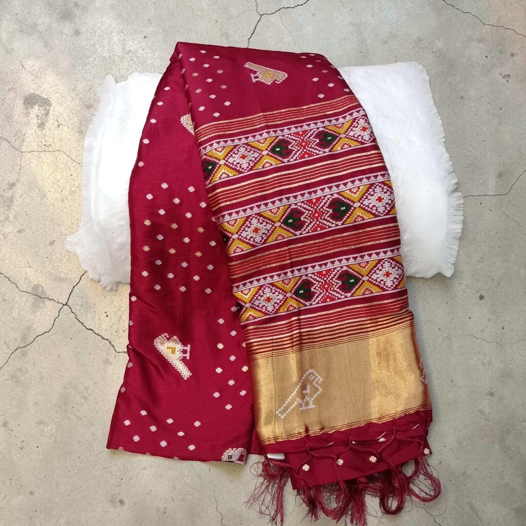 City Center maroon silk cotton saree with traditional Patola geometric patterns, gold zari border, and tassel details.
