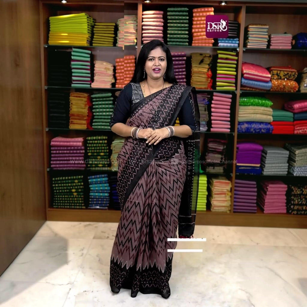 City Center premium cotton saree in mauve and black with geometric zigzag patterns worn by a woman in a store