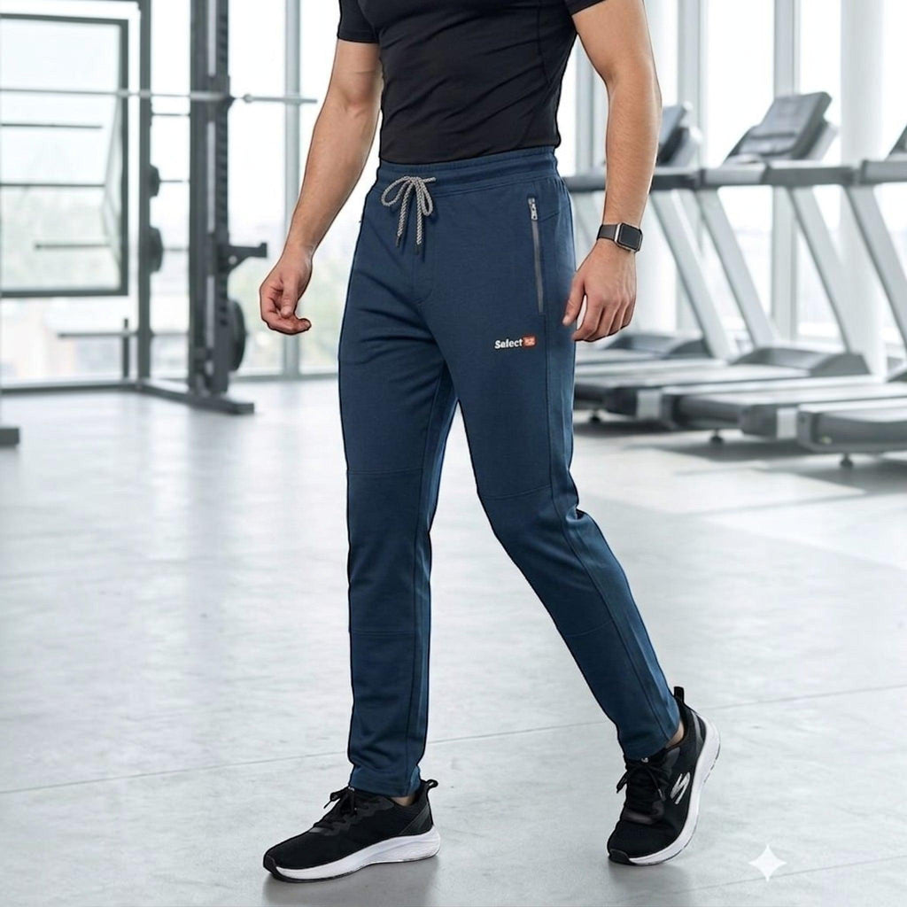 City Center men's navy blue athletic track pants with zipper pockets and drawstring waist in a gym setting.