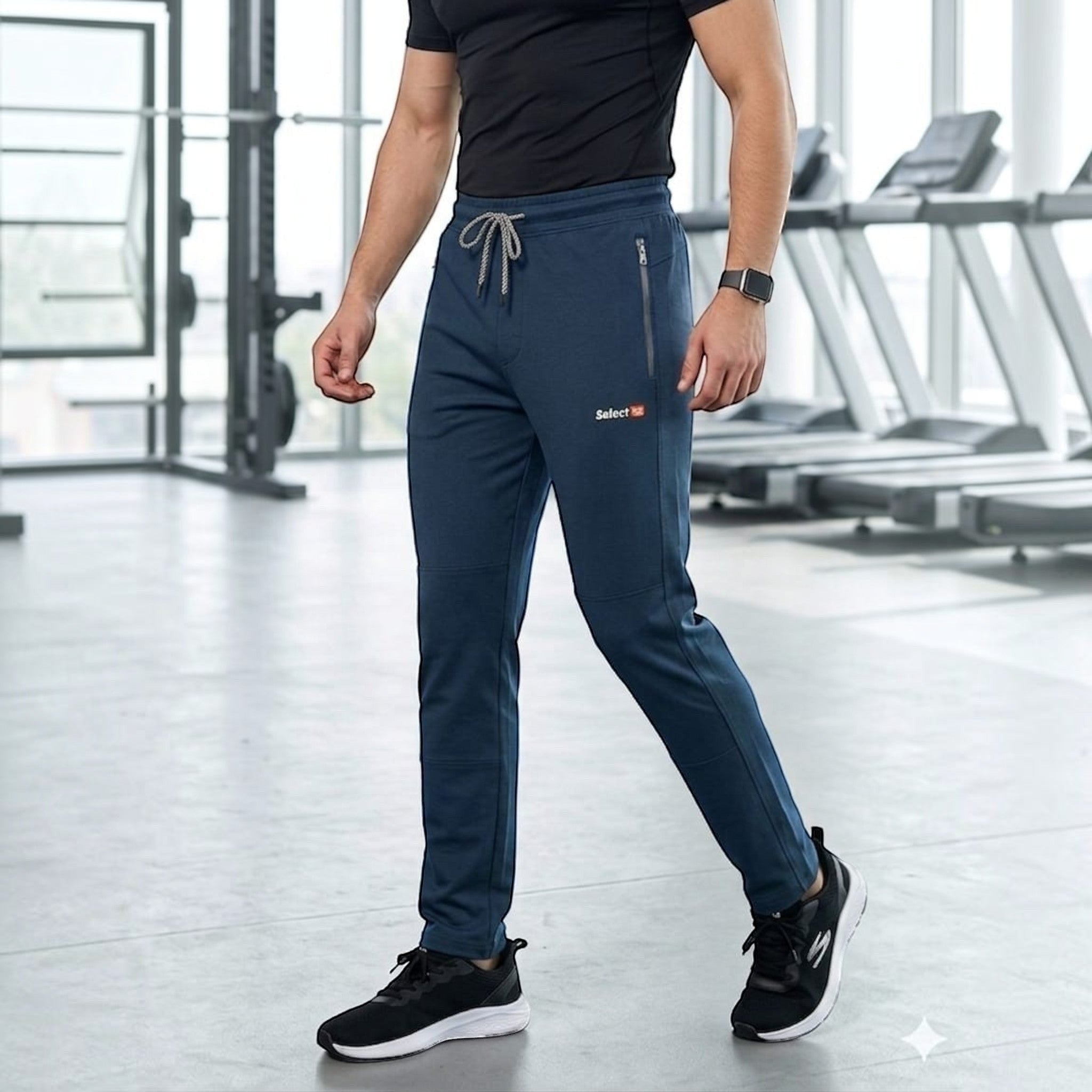 City Center men's navy blue athletic track pants with zipper pockets and drawstring waist in a gym setting.