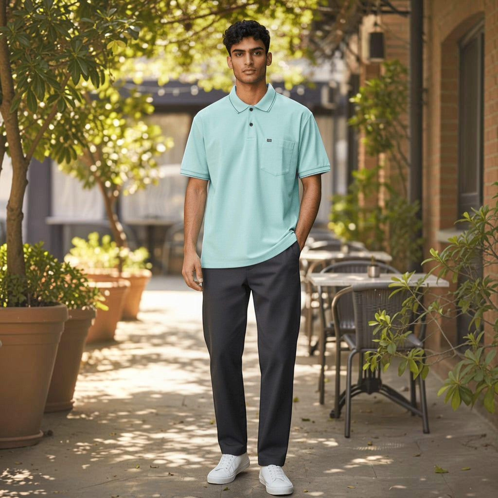 City Center men wearing a pastel mint green polo shirt with a chest pocket and dark trousers in an outdoor cafe setting