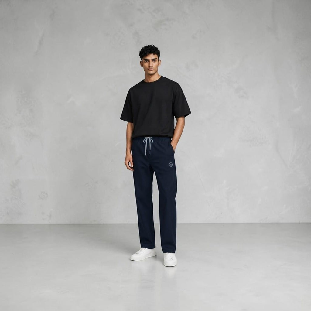 City Center navy blue track pants with an elastic drawstring waistband worn by a man in a black t-shirt