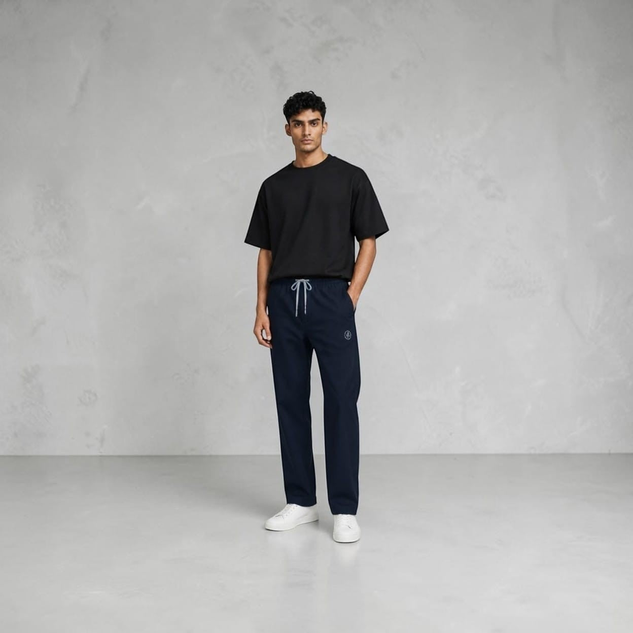 City Center navy blue track pants with an elastic drawstring waistband worn by a man in a black t-shirt