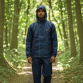 City Center Top N Town navy waterproof rainsuit with red accents and hood, worn by a man in a forest setting.