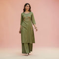 City Center olive green embroidered kurta and wide-leg palazzo set worn by a woman on a soft pink background.