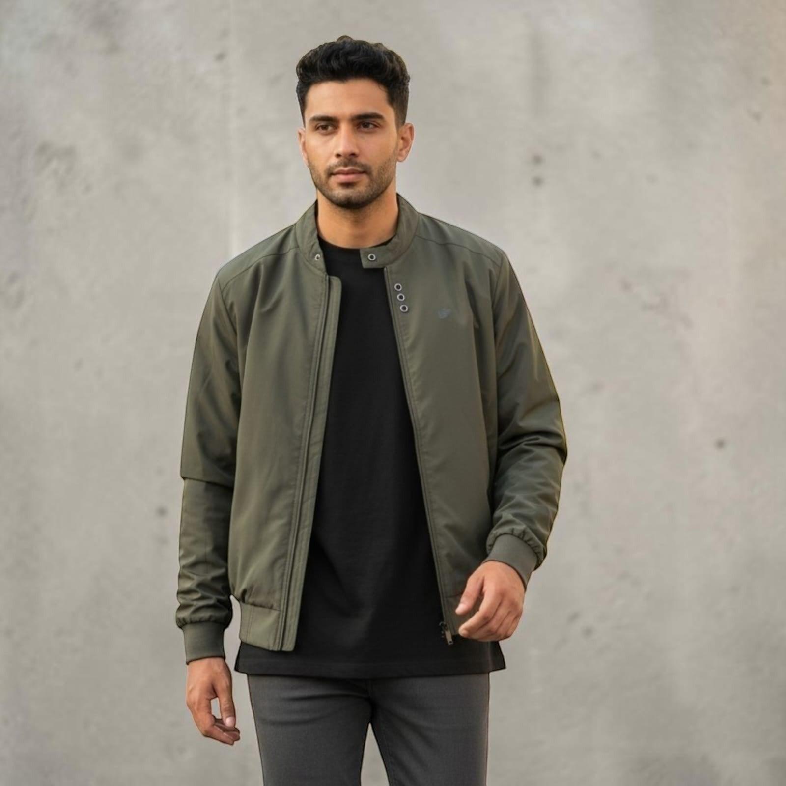 City Center olive green full-zip casual jacket worn by a man over a black t-shirt against a concrete wall background