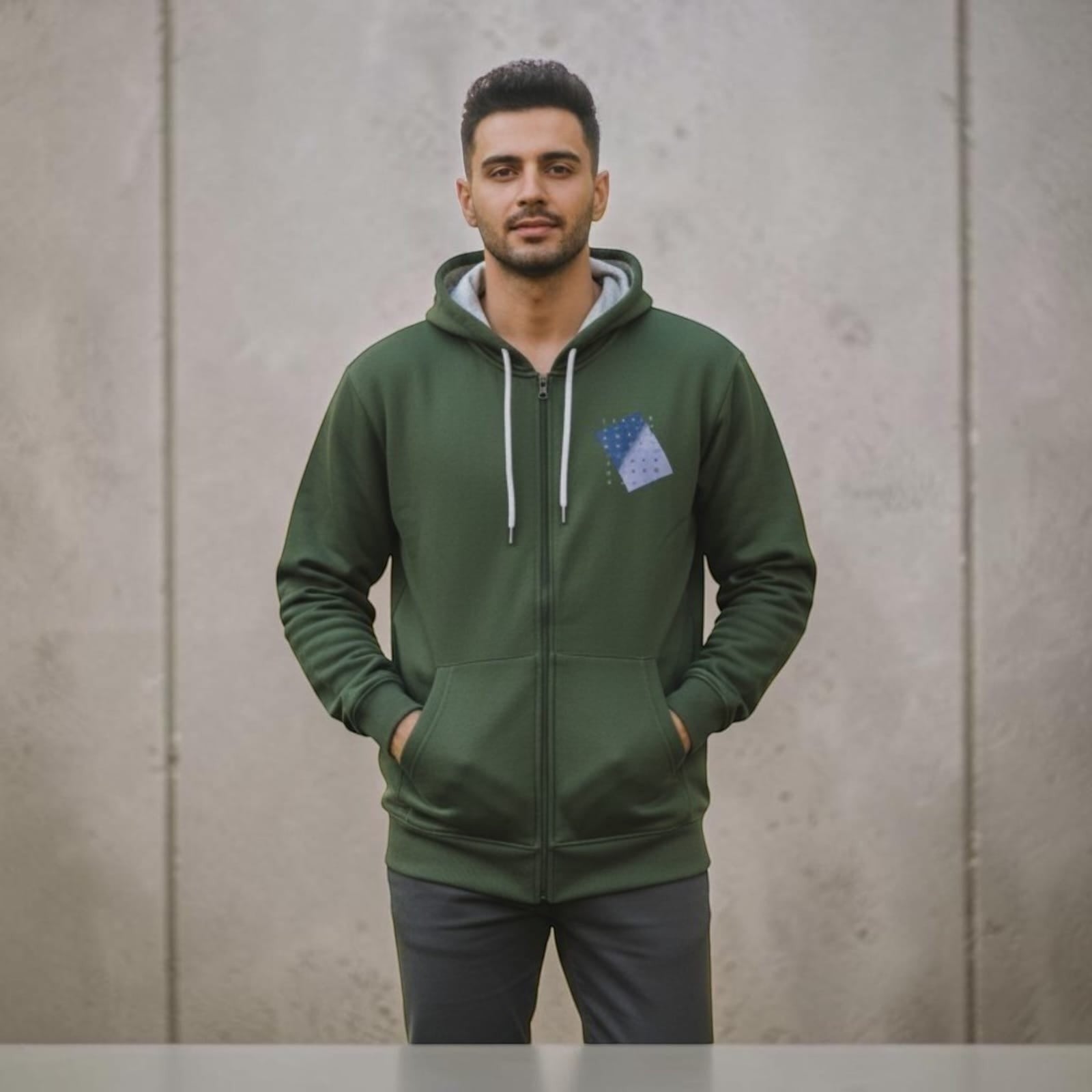 A man wearing a City Center olive green full-zip hoodie with a small blue chest patch and white drawstring cords.