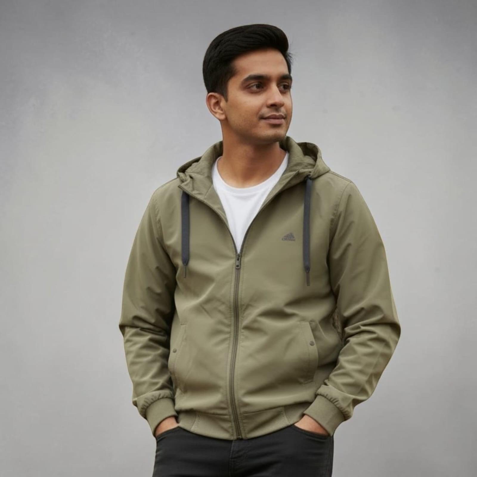 City Center olive green lightweight hooded jacket worn by a man over a white t-shirt against a grey background