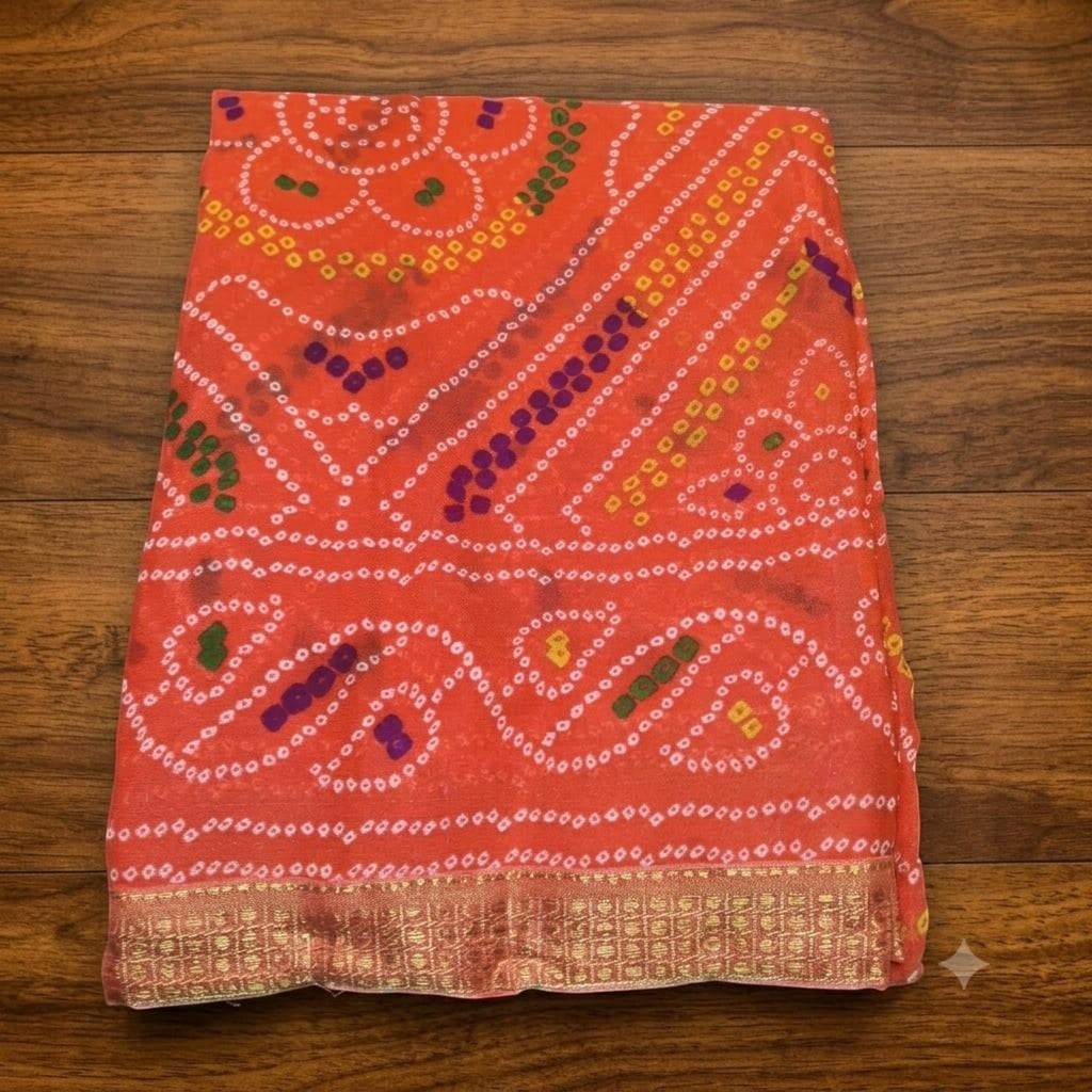 City Center Bandhan silk saree in vibrant orange with traditional white, yellow, and purple bandhani tie-dye patterns.
