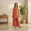 City Center orange patterned co-ord set with sleeveless tunic and wide-leg trousers worn by a smiling woman