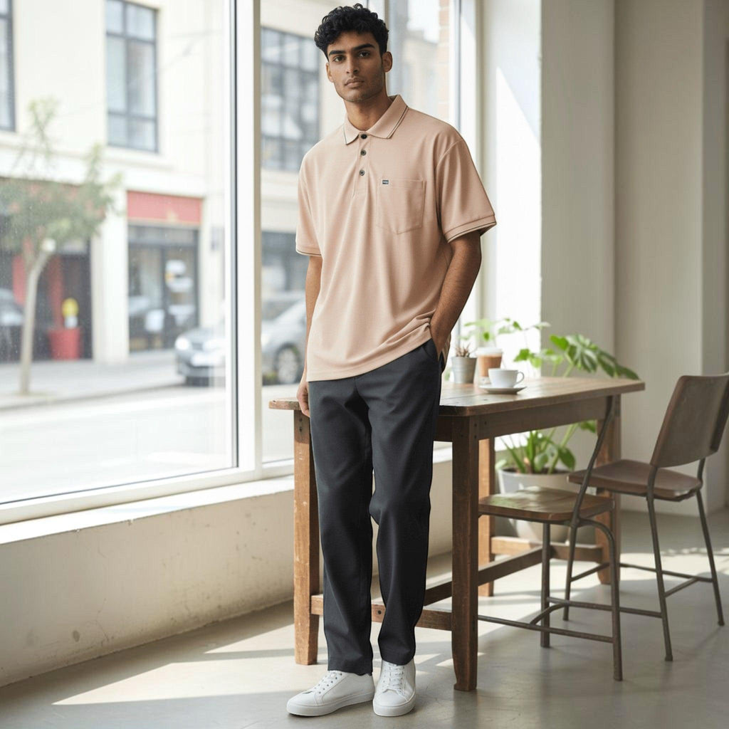 City Center men's pastel peach polo shirt with a chest pocket, worn by a model in a bright, modern indoor setting.