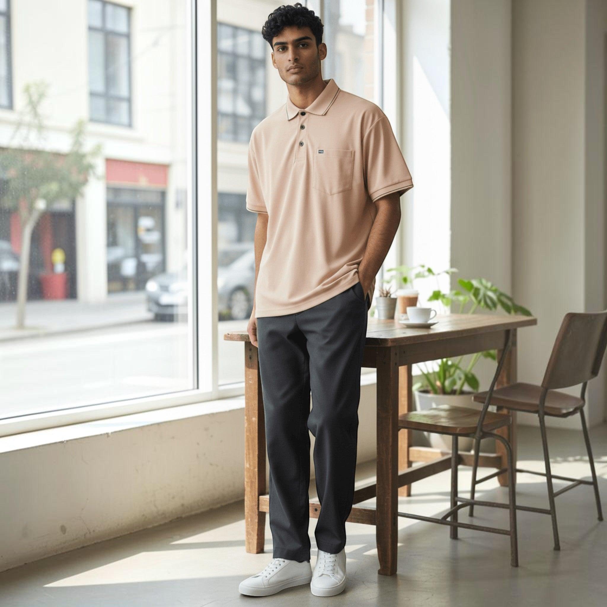 City Center men's pastel peach polo shirt with a chest pocket, worn by a model in a bright, modern indoor setting.