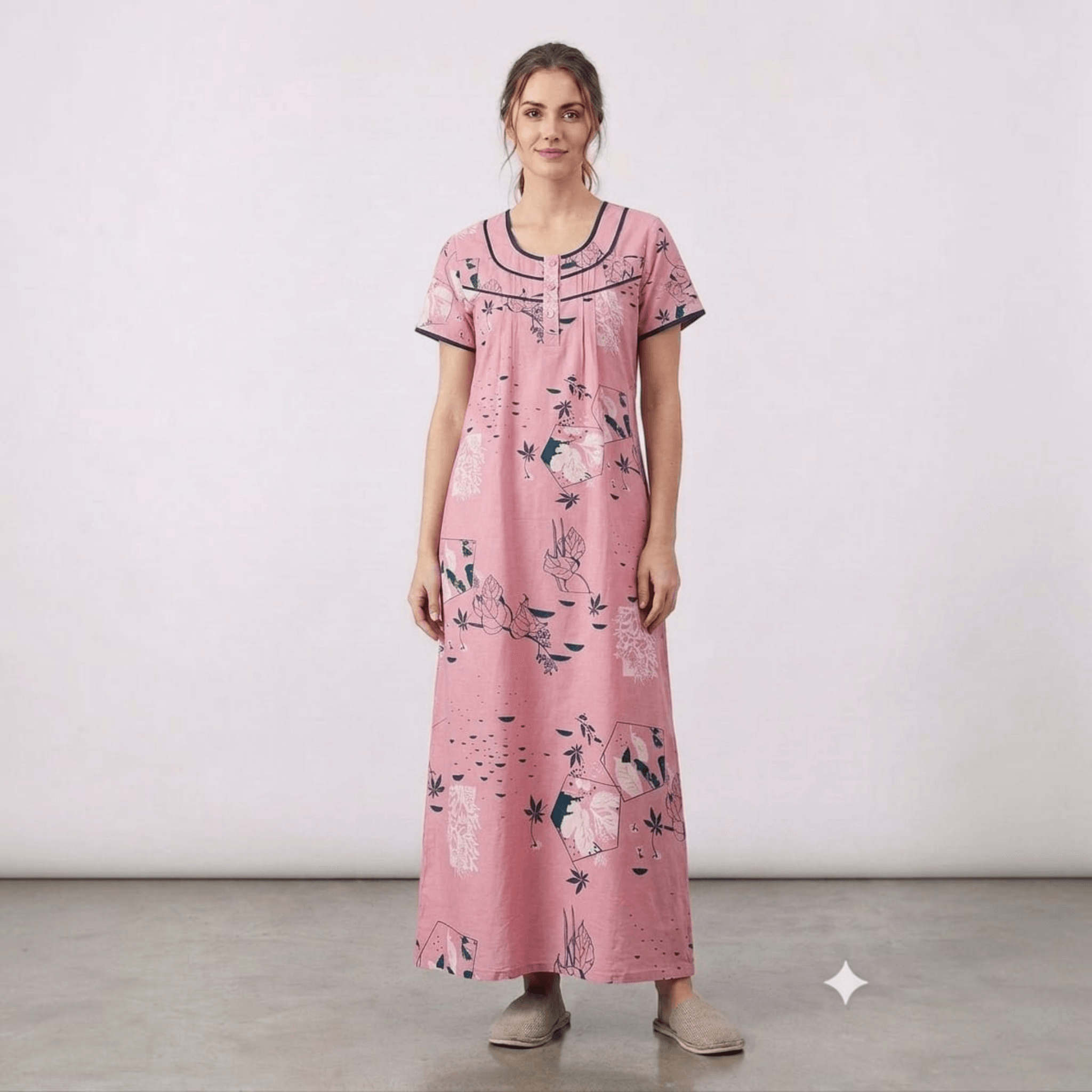 City Center pink alpine fabric feeding gown with floral print, neck embroidery, and front pleats on a model