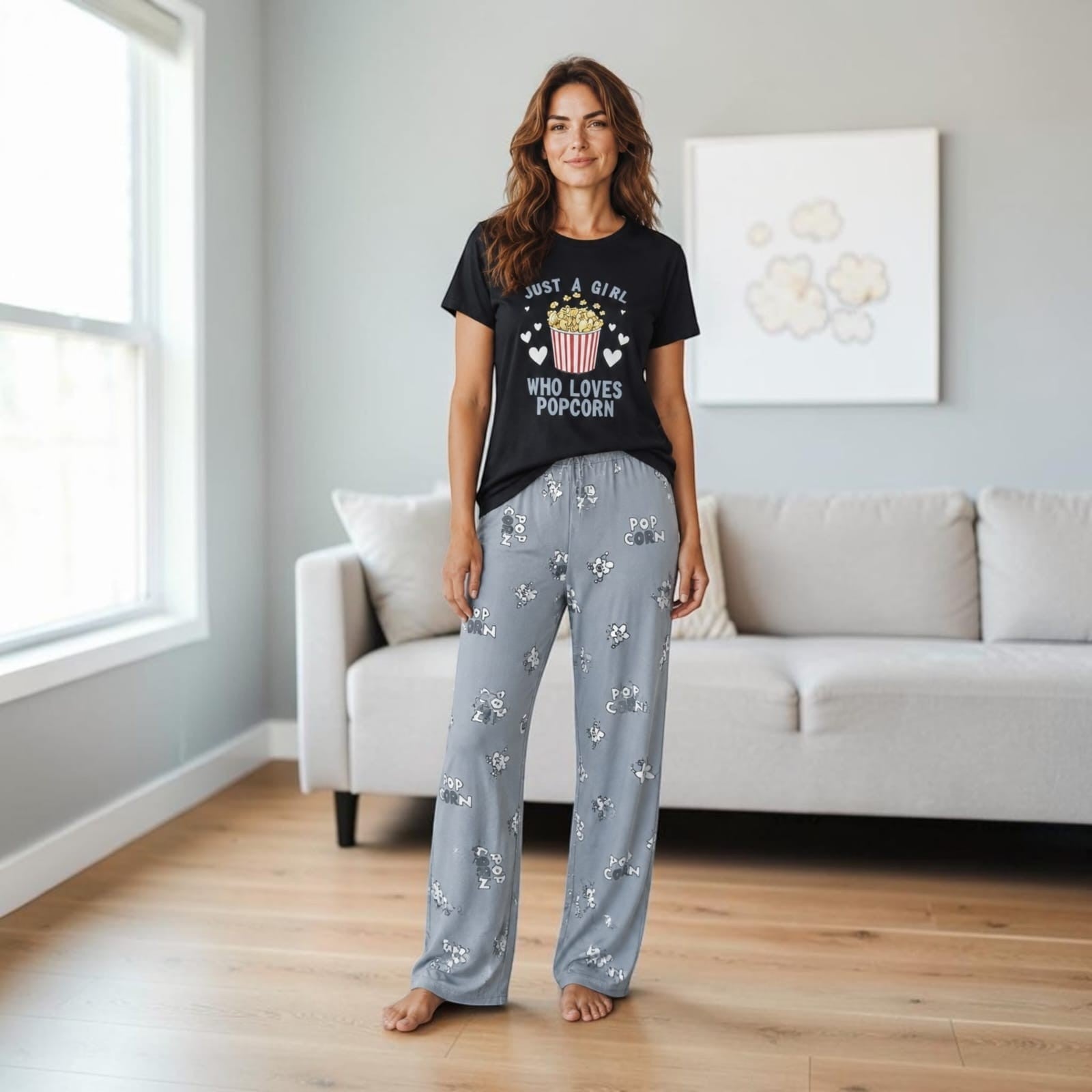 City Center woman wearing a black t-shirt with popcorn graphic and grey patterned pajama pants in a living room
