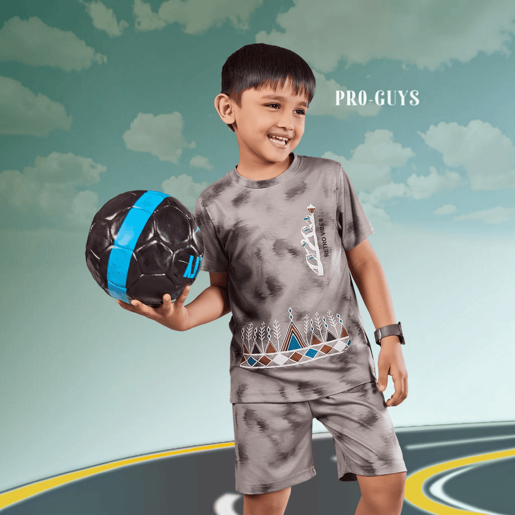 City Center Pro-Guys kids grey tie-dye cotton t-shirt and shorts set worn by a smiling boy holding a soccer ball