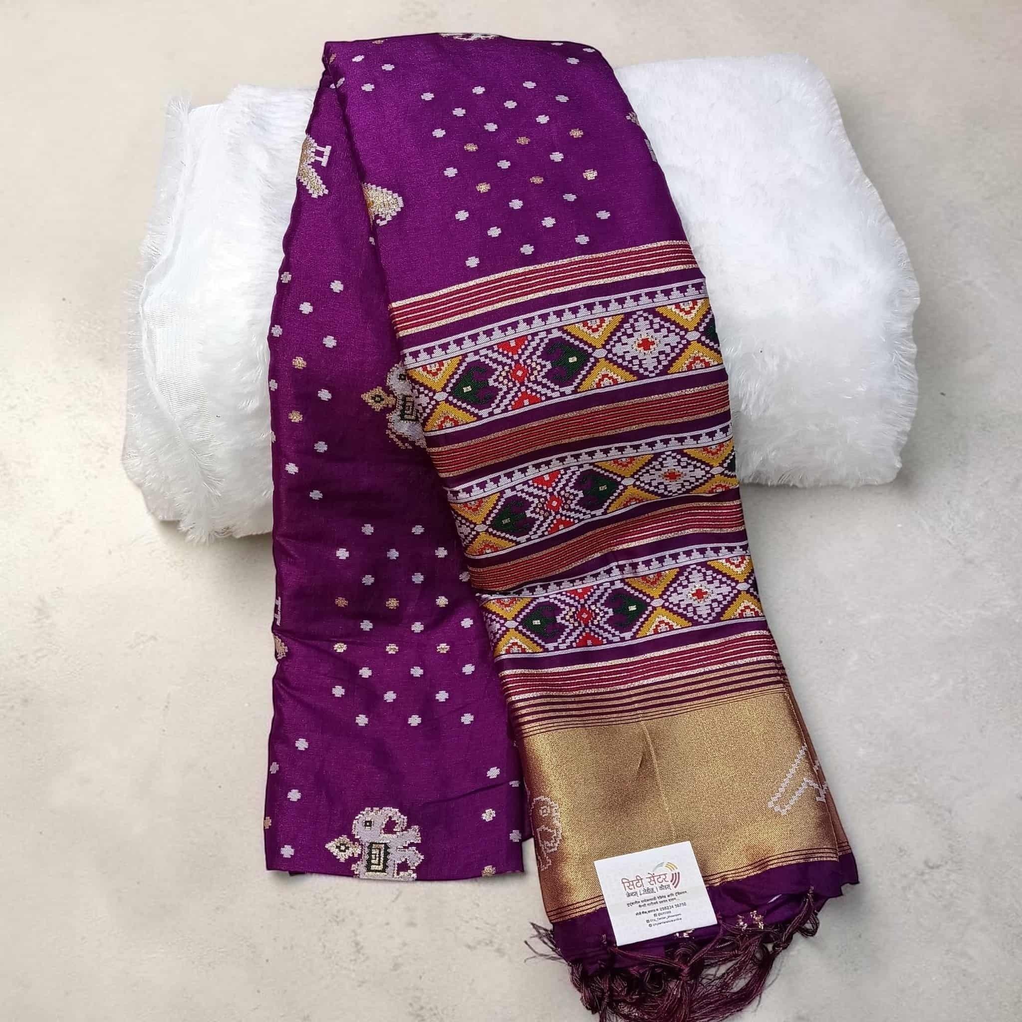 City Center purple silk cotton Patola saree with intricate geometric ikat patterns and a gold zari border.