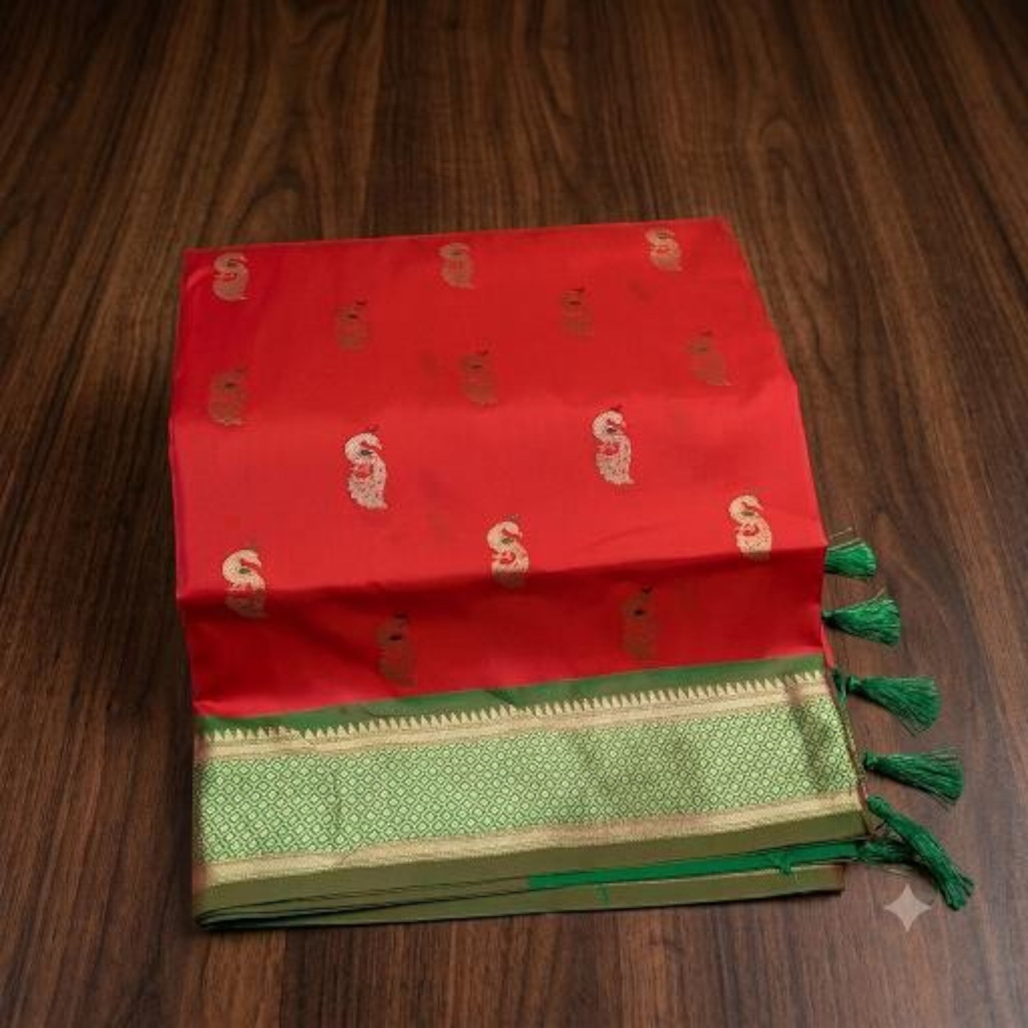 City Center red pure silk Paithani saree with gold zari peacock motifs and a green border on a wooden background