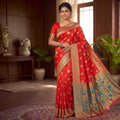 City Center red silk saree with intricate gold zari weaving and teal floral pallu worn by a woman in a formal setting