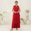 City Center red sleeveless collared tunic and wide-leg trousers co-ord set worn by a model in a studio setting.