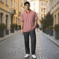 City Center M-Line polo shirt with red and white vertical stripes, worn by a man on a cobblestone street.