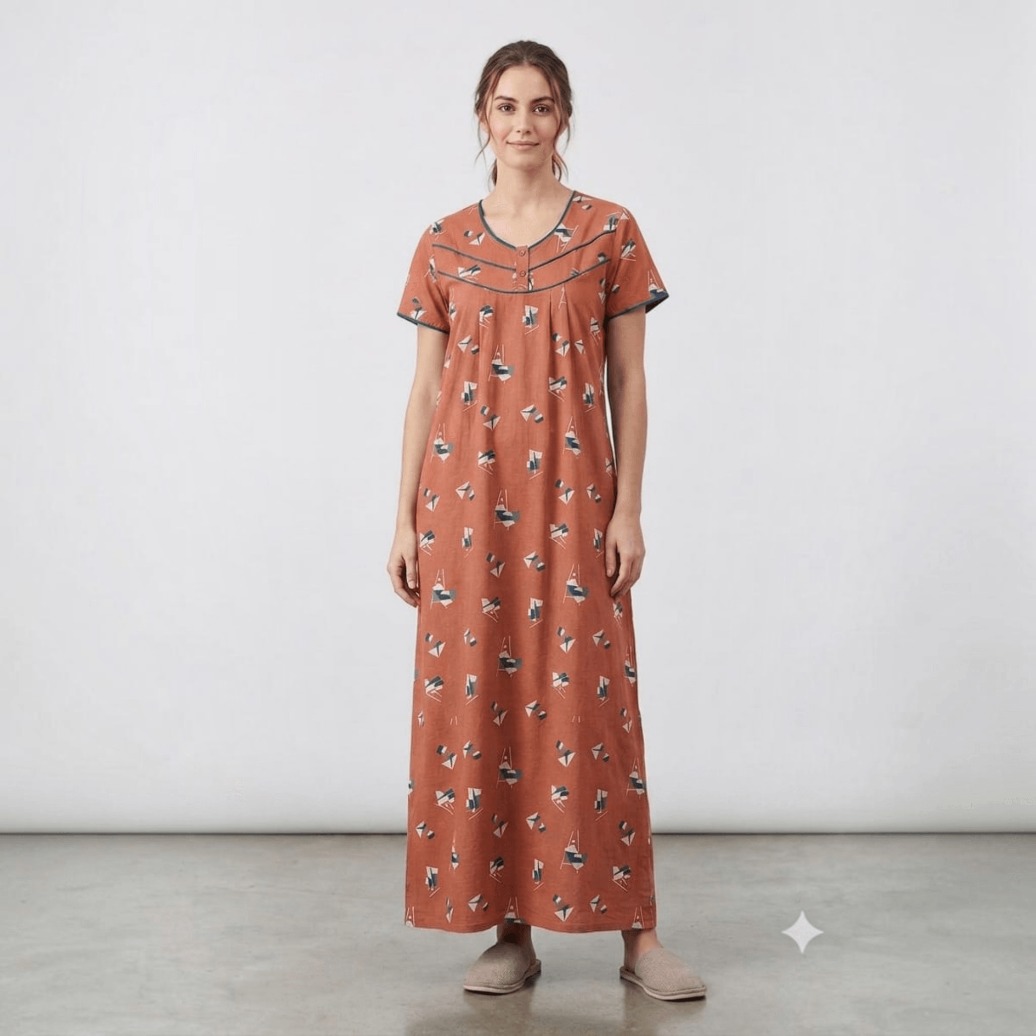 City Center women's rust-colored alpine fabric feeding gown with geometric print, neck embroidery, and pleats.