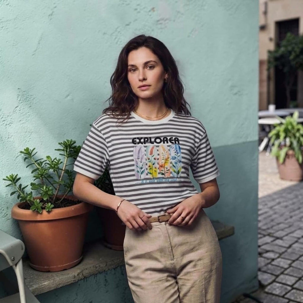 City Center premium cotton t-shirt with grey stripes and floral Explorer graphic print worn by a woman outdoors.