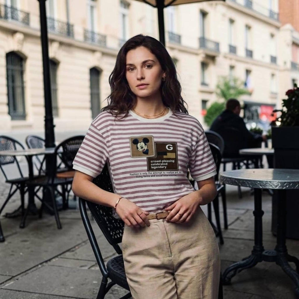 City Center premium cotton t-shirt with striped pattern and graphic print worn by a woman at an outdoor cafe