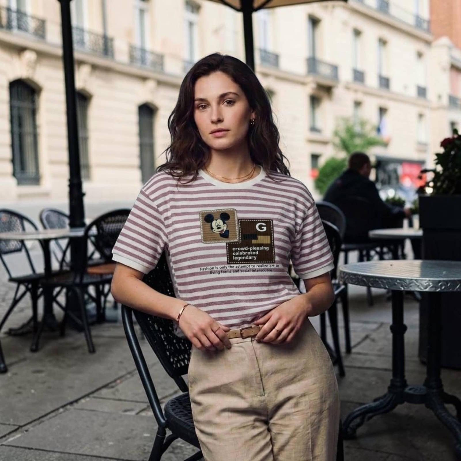 City Center premium cotton t-shirt with striped pattern and graphic print worn by a woman at an outdoor cafe