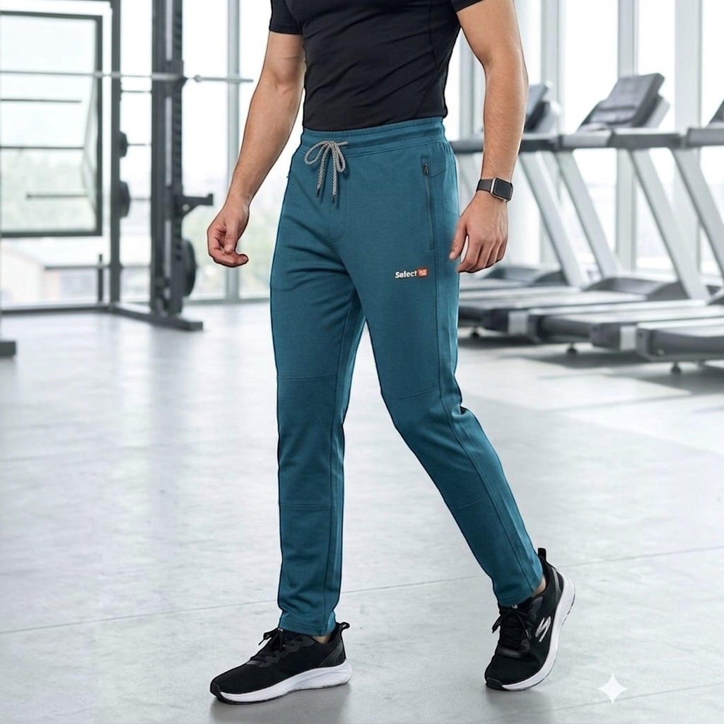 City Center men's teal premium athletic track pants with zippered pockets and drawstring waist in a gym setting