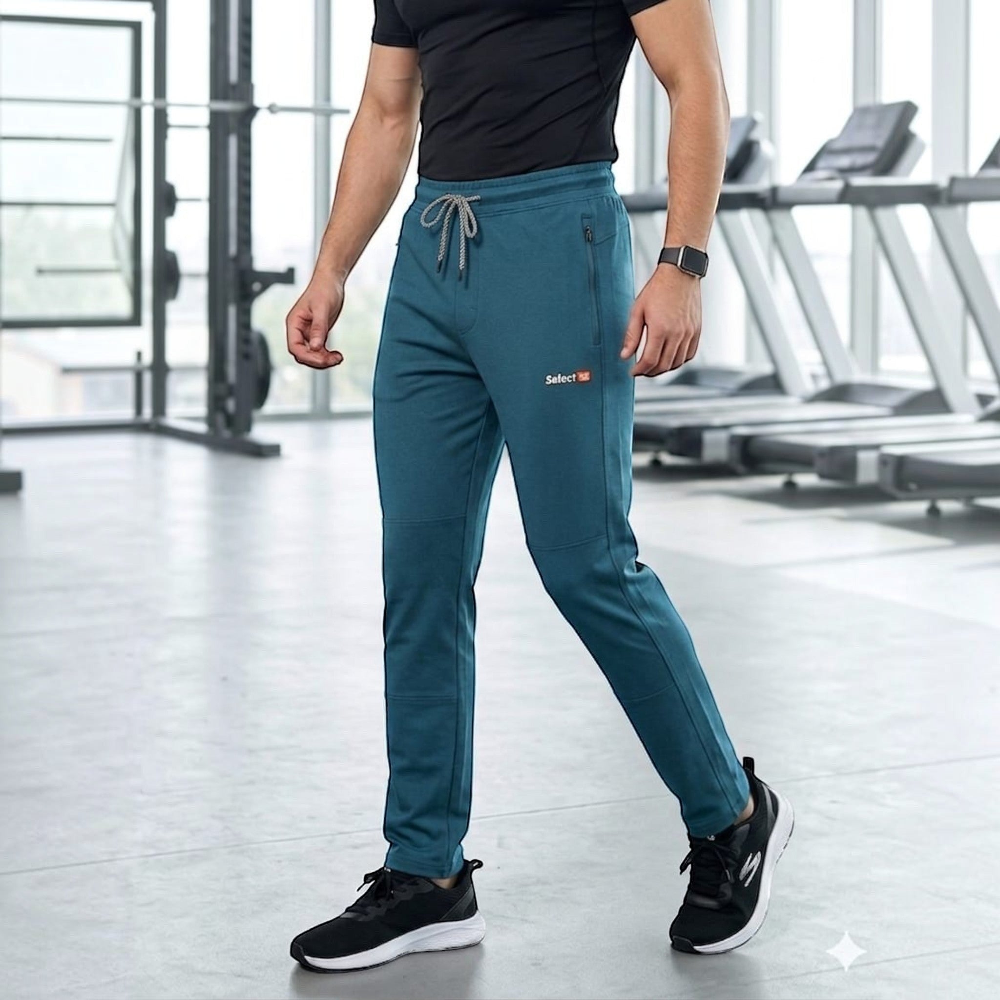 City Center men's teal athletic track pants with zippered pockets and drawstring waist in a gym setting