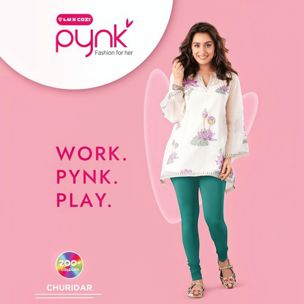 City Center PYNK by Lux Cozi teal churidar leggings worn by a woman with a white floral tunic on a pink background