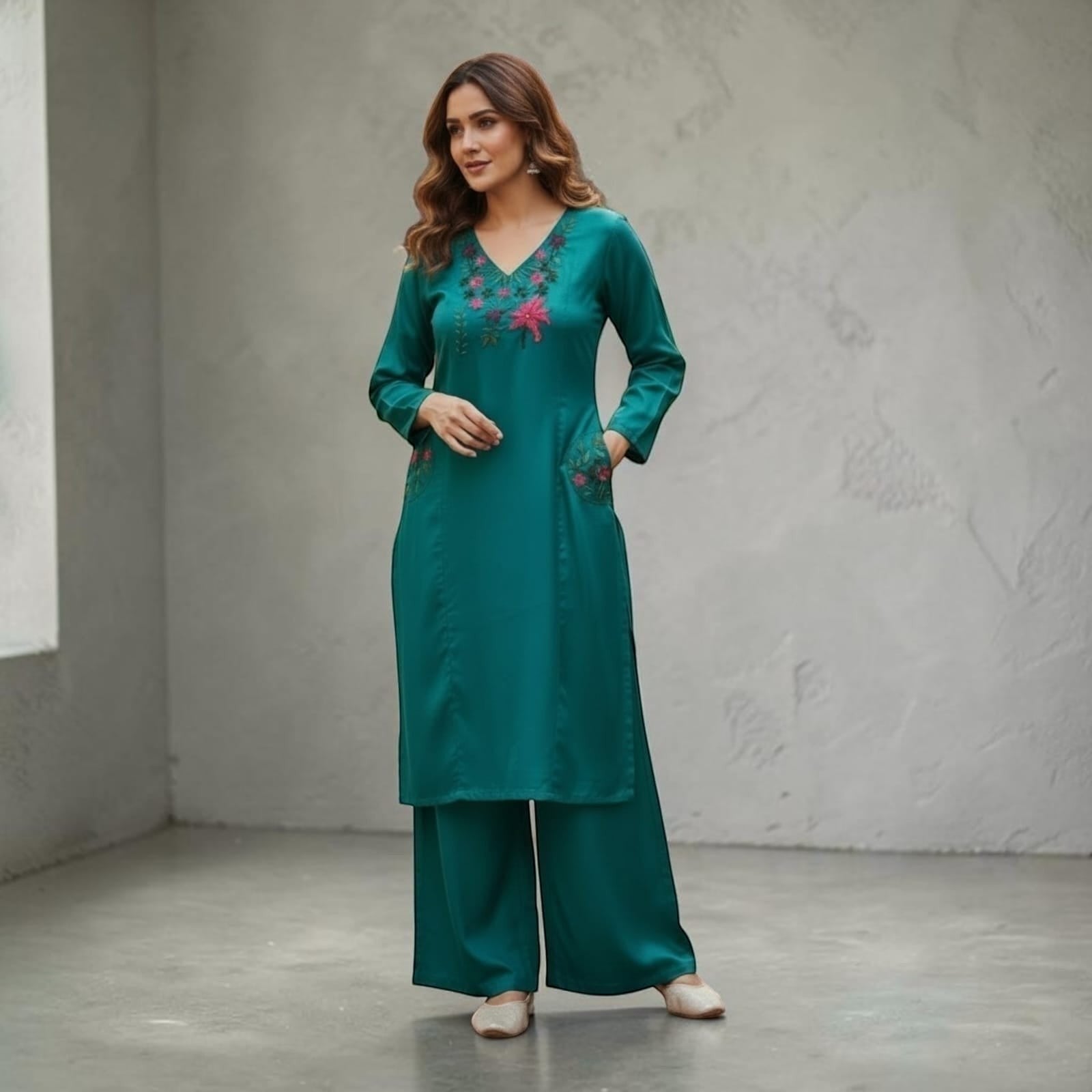 City Center teal kurta and palazzo set with floral embroidery on the neckline and pockets, worn by a woman.