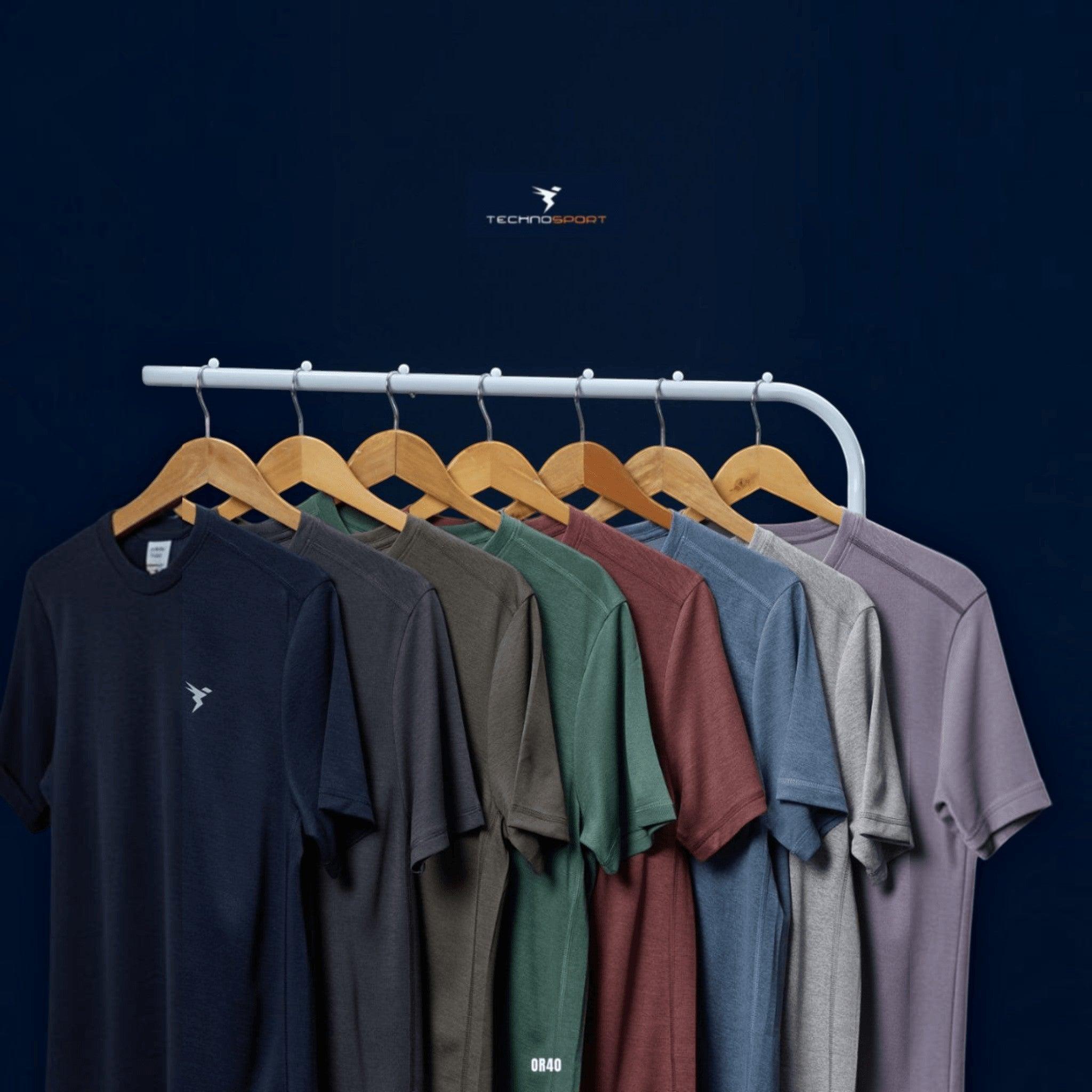 City Center Technosport athletic crew neck t-shirts in various colors on wooden hangers against a dark blue background.