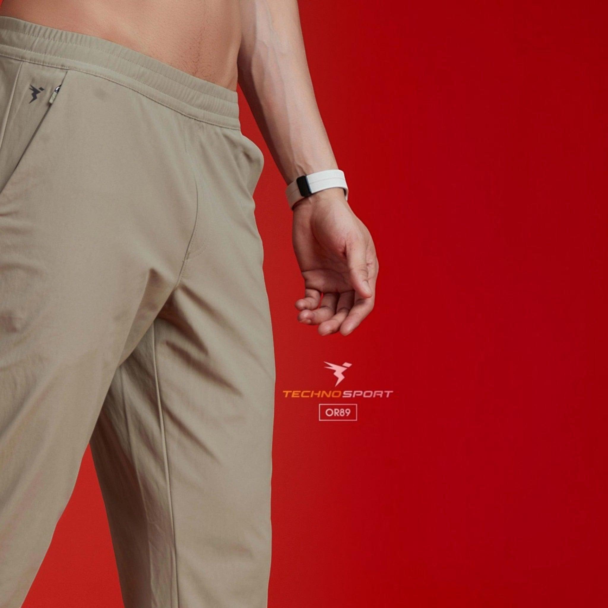 City Center Technosport beige 4-way stretch track pants with DuraCool+ moisture-wicking fabric on a model.