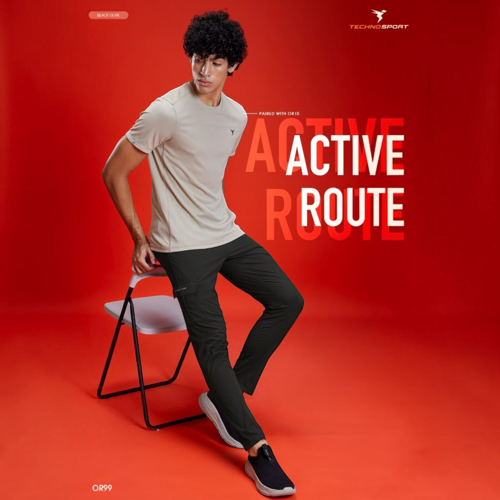 City Center model wearing Technosport TS Flexi solid woven black cargo pants with a beige t-shirt on a red background